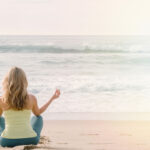 Femme faisant de la méditation et des respirations sur la plage
