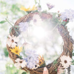 Femme qui tient une couronne de fleur blanche, violette et jaune