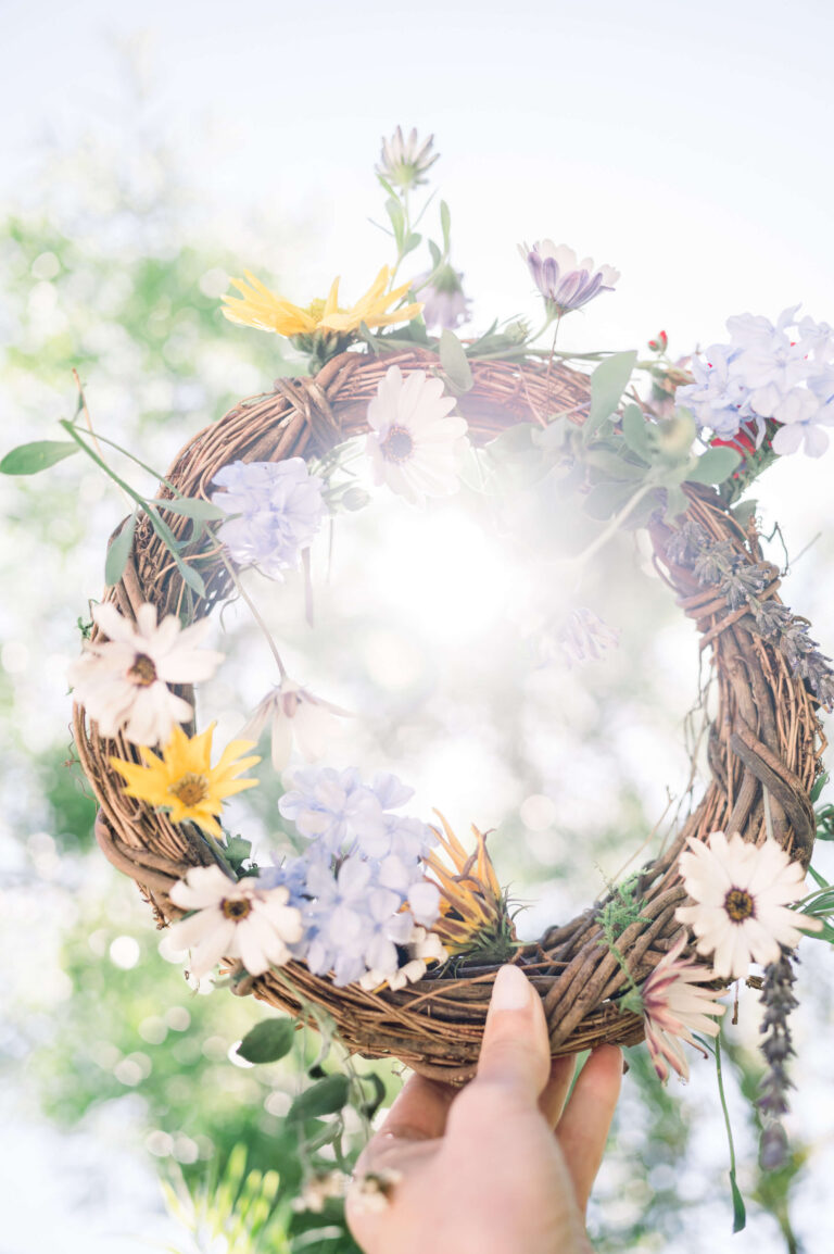 Femme qui tient une couronne de fleur blanche, violette et jaune