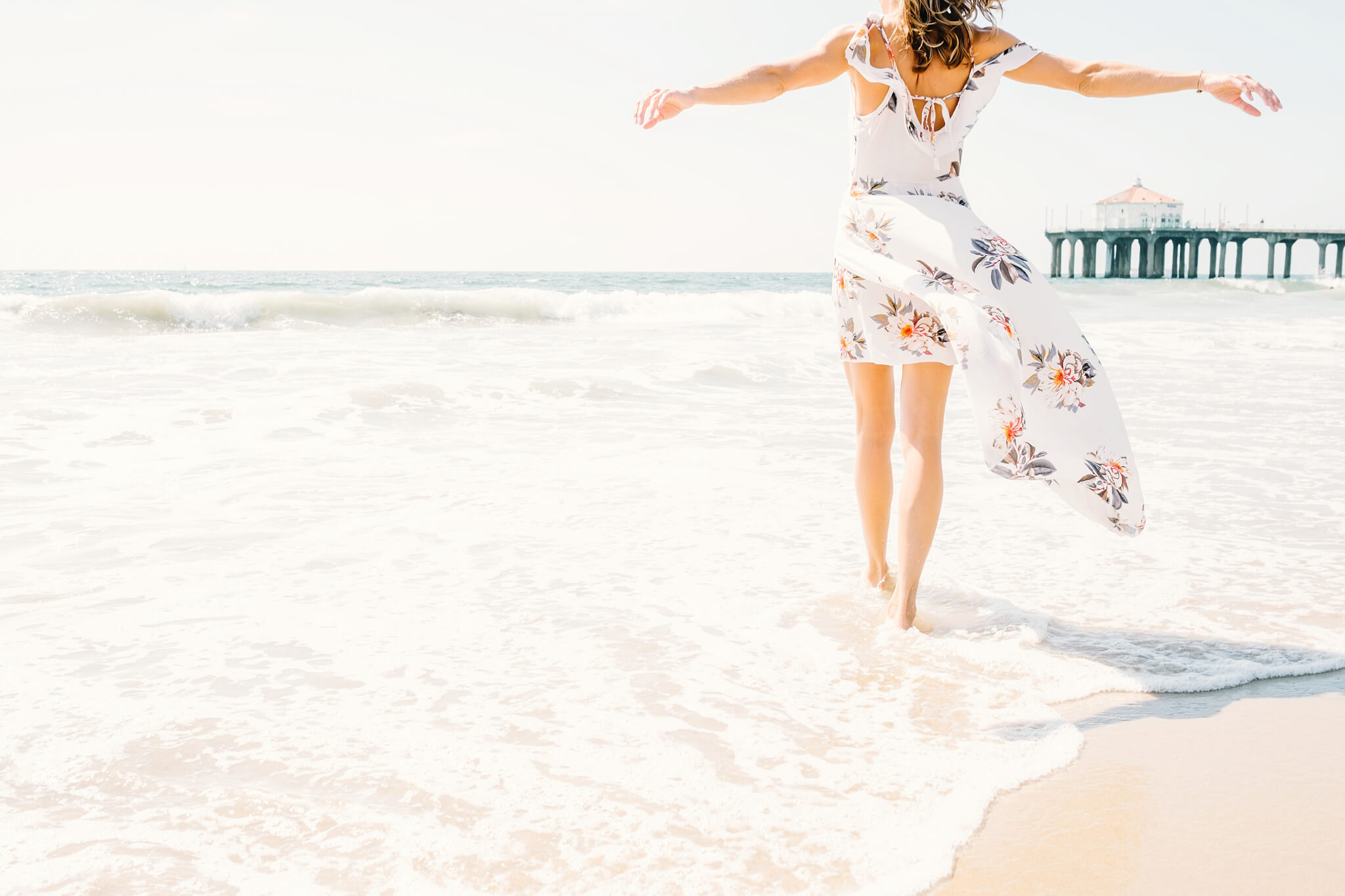 Femme heureuse et épanouie ouvrant les bras sur la plage