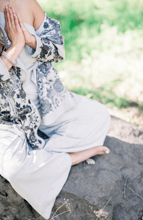 Femme en train de méditer dans un jardin en paix