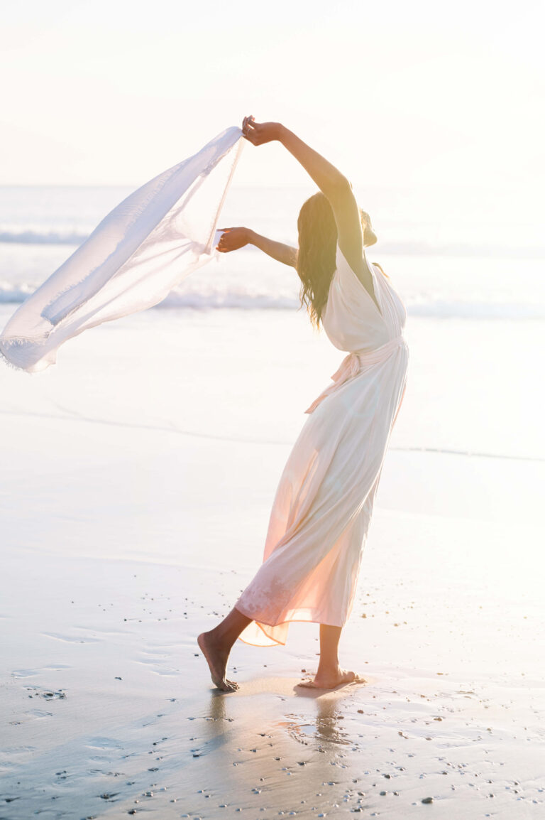 Femme levant les bras au ciel avec un foulard blanc