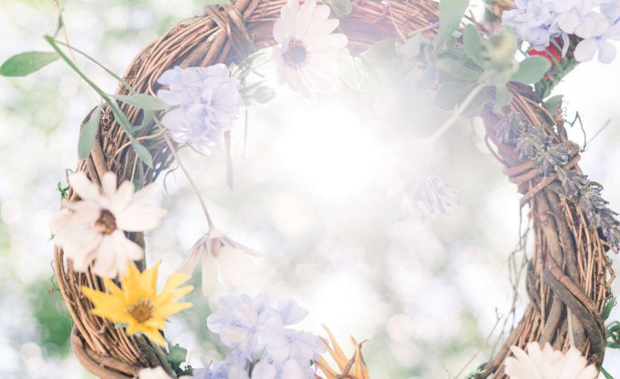 Femme qui tient une couronne de fleur blanche, violette et jaune