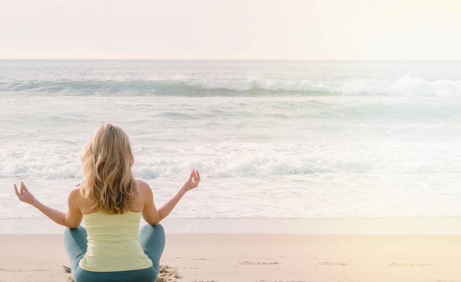 Femme faisant de la méditation et des respirations sur la plage